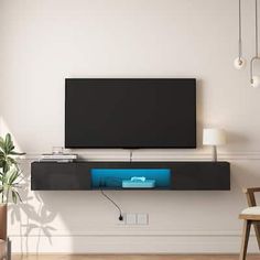 a flat screen tv mounted to the side of a white wall in a living room