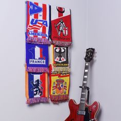 an electric guitar and several scarfs hanging on the wall