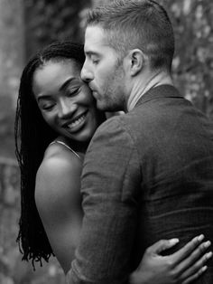 a man and woman embracing each other in black and white