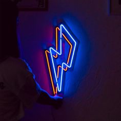 a neon sign that is on the side of a wall