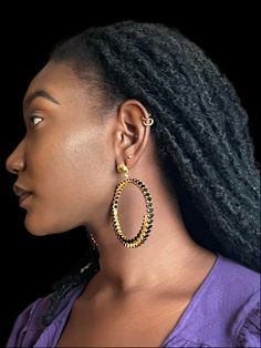 Embrace the bold elegance of the ALLIYETTE Endless Onyx Hoop Earrings, where timeless sophistication meets modern flair. These captivating hoops feature 59 rich onyx gemstones on each earring, symbolizing strength and resilience, beautifully set within 18k gold-plated hoops. The unbroken circle design signifies continuity and empowerment, making this piece a statement of confidence. Though slightly weighty, the luxurious craftsmanship ensures these earrings will leave a lasting impression at any event or gathering. Product Details - 18K Gold Vermeil- Garnet- Length 65mm - Width 52mm What is Gold Vermeil? Unlike regular gold plating, Gold vermeil is a thick layer of solid gold over sterling silver that is made to last. Often referred to as affordable luxury, Gold vermeil jewelry gives you t Luxury Black Diamond Round Earrings, Luxury Round Black Diamond Earrings, Single Black Luxury Earring, Luxury Black Single Earring, Modern Yellow Gold Jewelry With Black Diamonds, Luxury Hoop Jewelry With Halo Detail, Clip-on Round Hoop Earrings For Evening, Modern Hoop Jewelry For Evening, Modern Black Hoop Jewelry