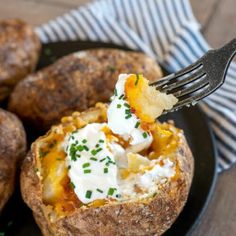 a fork in a baked potato with sour cream