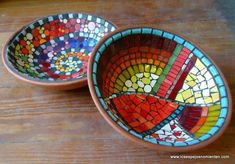 two colorful bowls sitting on top of a wooden table