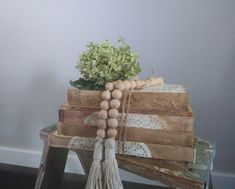 a bunch of wood beads are on top of some wooden boxes and a plant is in the background