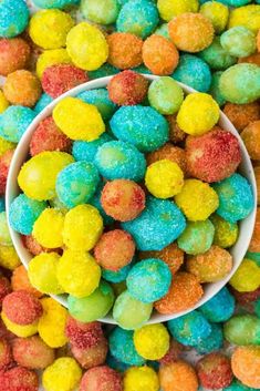 a white bowl filled with colorful candies on top of a table