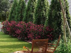 a wooden rocking chair sitting on top of a lush green field