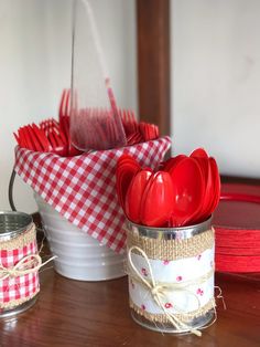 red utensils are sitting in tins on a table