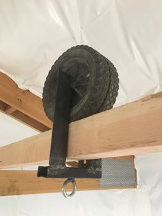 a tire mounted to the side of a wooden beam