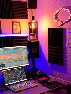 a laptop computer sitting on top of a wooden desk next to a monitor and speakers