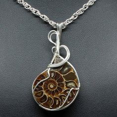 "Wire Wrap Jewelry Description:  *Designer Cabochon Gemstone: Ammonite (30mm x 30mm Round Shaped) *Approximate size:  2 1/4\" long including bail x 1 1/4\" at widest point *Includes Free Rope Chain *Free Domestic Shipping - Arrives in Gift Box - Gift Wrapping Available  The contemporary wire wrap jewelry is hand wire sculptured using sterling silver wire around the natural Ammonite cabochon gemstone to form this simple delicate handmade wire wrap pendant statement necklace. The bail is large enough to accommodate various style chains. Each wire wrap pendant is handmade by me from inception to finished product. They are not mass produced nor manufactured; each unique piece is one of a kind. This is the exact pendant you will receive when purchased. We welcome general inquiries - Just Ask yo Spiral Wire Wrapped Sterling Silver Necklace, Nature-inspired Sterling Silver Wire Wrapped Necklaces, Nature-inspired Wire Wrapped Sterling Silver Necklaces, Nature-inspired Sterling Silver Wire Wrapped Jewelry, Nature-inspired Wire Wrapped Round Jewelry, Nature-inspired Round Wire Wrapped Jewelry, Spiral Natural Stones Jewelry Gift, Artisan Spiral Nickel Free Jewelry, Spiral Wire Wrapped Necklace For Gift