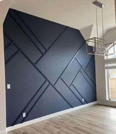 an empty room with blue walls and wooden floors