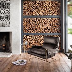 a living room with wood stacked on the wall and a chair in front of it