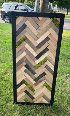 a wooden box sitting in the grass next to a tree