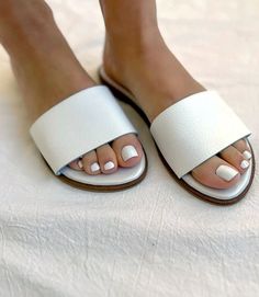 Elevate your style effortlessly with the simplicity of chic fashion in these versatile slide sandals, allowing you to pair them with anything from casual denim to a breezy summer dress. Whether you're strolling through the city streets or enjoying a leisurely day at the beach, these comfortable leather sandals are made for your every adventure. 100% Leather Imported Soft pillow sole Runs small and narrow; we recommend sizing up Rub with dry cloth | Karen Kane Leather Sandals in White, Size 36, P Trendy Slip-on Mules For Summer, Trendy Summer Slip-on Mules, Modern Flat Footbed Sandals For Spring, Trendy Round Toe Slides For Spring, Modern Slip-on Sandals For Summer, Trendy Slip-on Slides For Summer, Trendy Slip-on Summer Slides, Trendy Summer Slip-on Slides, Summer Slides With Open Heel