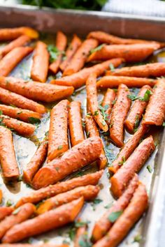 cooked carrots on a baking sheet ready to be baked in the oven with parsley