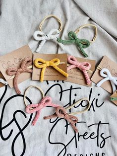 small crocheted bows are laid out on top of a t - shirt that says stitch street designs