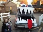 two people standing in front of a car decorated like a monster with teeth and fangs