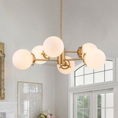 a chandelier hanging from the ceiling in a room with white walls and windows