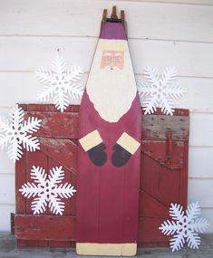 a santa clause standing in front of snowflakes on the side of a building