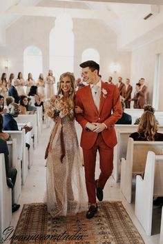 a bride and groom walking down the aisle