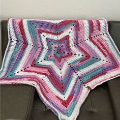 a crocheted blanket sitting on top of a couch