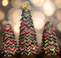 three small christmas trees with bows on them