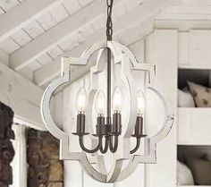 a chandelier hanging from the ceiling in a room with white walls and wood beams