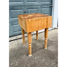 a small wooden table sitting in front of a garage door