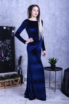 a woman in a long blue dress posing for the camera