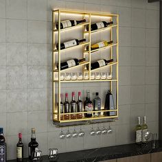 a wall mounted wine rack with bottles and glasses on it in front of a bar