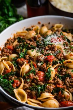 a close up of a plate of pasta with meat and spinach