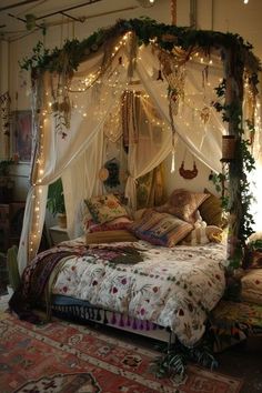 a canopy bed is decorated with lights and greenery for the headboard, foot board, and pillows