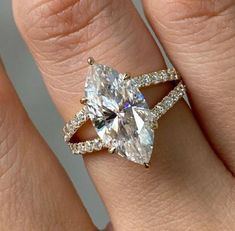 a woman's engagement ring with an oval cut diamond in the center and pave band