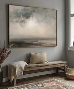 a large painting hanging on the wall above a wooden bench in front of a window