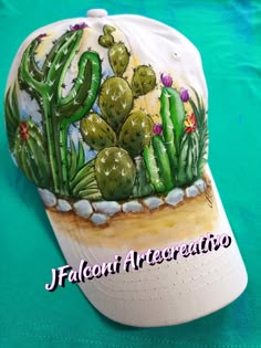 a white hat with cactus designs on it sitting on top of a blue tablecloth