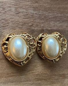 Vintage faux pearl clip on earrings. Gold coloured heart-shaped settings with oval faux pearl cabochons. Excellent condition. Clip on closures.  Earrings are not intended to be worn while sleeping bathing or swimming. Not recommended for children under three. See more: https://www.etsy.com/ca/shop/CleverLittleEars Canadian prices include Gst/hst where applicable While the cost of shipping makes returns or exchanges impractical, please do contact me with any concerns about your order and we will Luxury Formal Cabochon Clip-on Earrings, Luxury Vintage Cabochon Clip-on Earrings, Luxury Clip-on Oval Cabochon Earrings, Colorful Heart, Earrings Gold, Clip On, Clip On Earrings, Faux Pearl, Heart Shapes