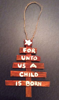 a wooden christmas tree ornament with the words for unto us a child is born