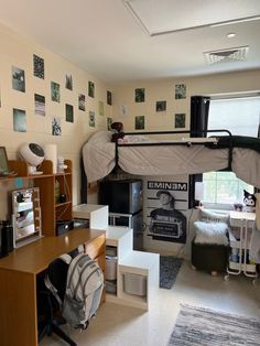 a dorm room with bunk beds, desks and pictures on the wall above it