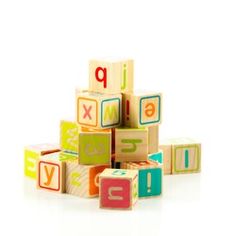 a pile of wooden blocks with letters and numbers on them, all stacked up in the shape of cubes