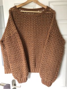 This beautiful unisex handmade crochet sweater jumper is perfect for any fashion- conscious woman or man. With its long sleeves, round neck- line, and pullover style, it's both comfortable and stylish. The jumper is made from high- quality acrylic material and comes in a brown colour that is sure to compliment any outfit. The jumper is available in XL size, making it a perfect fit for most. Whether you are looking for a jumper for everyday wear or for a special occasion, this handmade piece is s Casual Crochet Crew Neck Sweater, Oversized Crochet Long Sleeve Tops, Casual Cropped Long Sleeve Crochet Sweater, Casual Yarn Sweater For Fall, Crochet Knit Long Sleeve Cropped Sweater, Brown Open Knit Crew Neck Sweater, Cropped Knit Sweater With Crochet Long Sleeves, Cropped Long Sleeve Knit Sweater With Crochet Detail, Casual Fall Sweater In Yarn