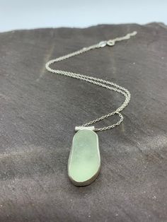 IDEAL CHRISTMAS GIFT!  Individually handmade sterling silver pendant with a beautifully smooth sea glass nugget in seafoam green. The glass is sourced in Kintyre on the west coast of Scotland.  The naturally tumbled sea glass is set in a fine silver bezel and sits on a hand-sawn open backed sterling silver backplate with wave design, allowing the light to shine through. The pendant is suspended by a tube bail on a delicate sterling silver chain - please select your preferred length at checkout. Unique Silver Jewelry With Recycled Glass, Silver Sea Glass Round Pendant Jewelry, Nickel-free Silver Necklaces With Recycled Glass, Nickel-free Silver Necklaces Made Of Recycled Glass, Nickel-free Silver Necklace Of Recycled Glass, Nickel Free Silver Necklace Of Recycled Glass, Silver Recycled Glass Necklace For Gift, Minimalist Silver Sea Glass Necklace, Seafoam Sea Glass Jewelry For Gifts