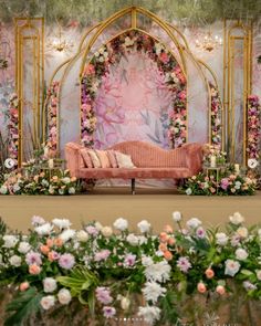 a pink couch sitting in front of a floral backdrop