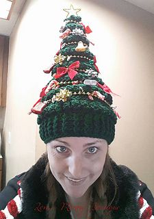 a woman wearing a knitted christmas tree hat