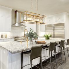 a large kitchen with an island and bar stools next to the stove top oven