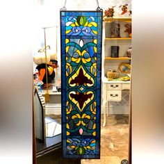 a stained glass window hanging from the side of a wall in a room with shelves