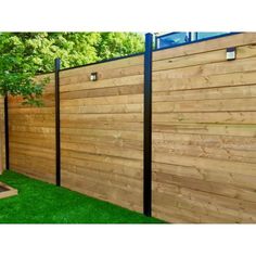 a wooden fence with black posts and a blue sign on the side that says,