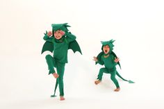 two children in green dragon costumes are dancing