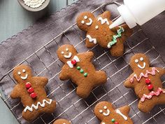 several gingerbreads on a cooling rack with some candy in the bowl next to them