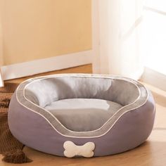 a gray dog bed with a white bone on it