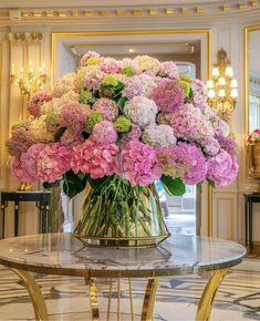 a vase filled with pink and white flowers on top of a table